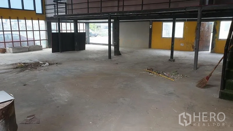 Warehouse for rent in Huai Khwang, Bangkok - Open-plan warehouse with floor-to-ceiling windows, steel columns, and abundant natural light.