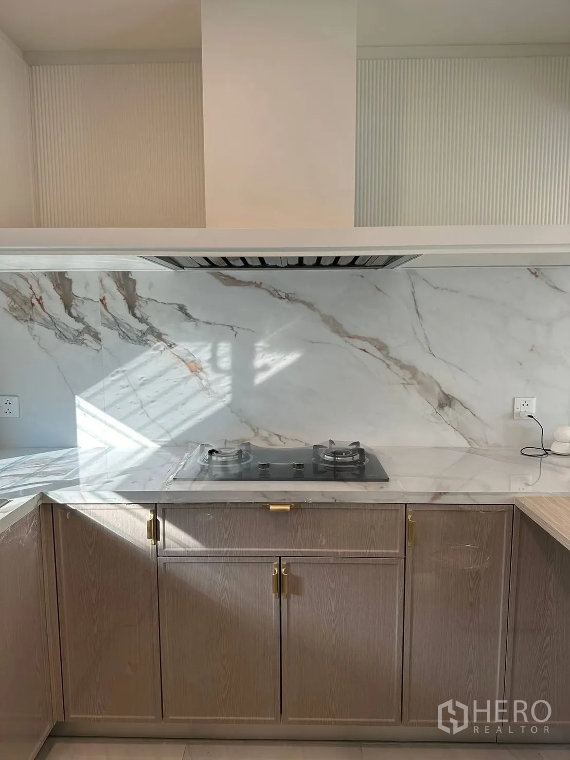 Detached House for rent in Bang Phli, Samut Prakan - Kitchen with marble backsplash, gas cooktop, and wood cabinetry.