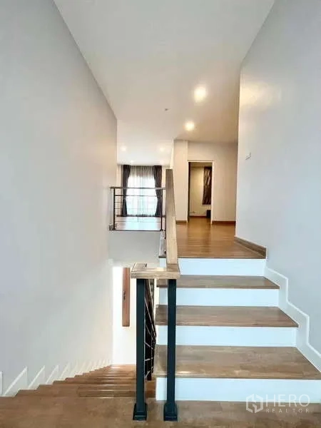 Detached House for rent in Don Mueang, Bangkok - Staircase with wooden steps and metal balustrade to upper floor landing.