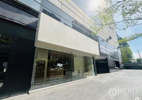 Retail Space for rent - Modern commercial building with wide glass storefront and driveway in the Sukhumvit Phrom Phong area.