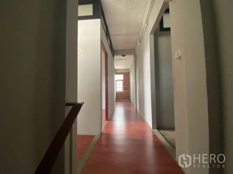 Retail Space for rent in Khlong San, Bangkok - Long hallway with wood-look floors and rooms on both sides.