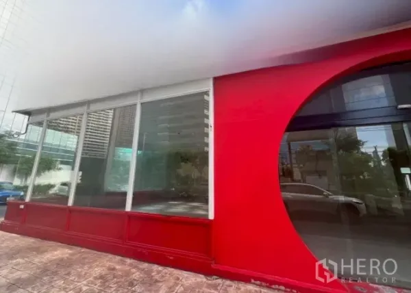 พื้นที่ขายปลีก ให้เช่า - หน้าร้านมุมอาคาร กระจกเต็มบานรอบด้าน กรอบสีแดง เห็นเด่นชัด