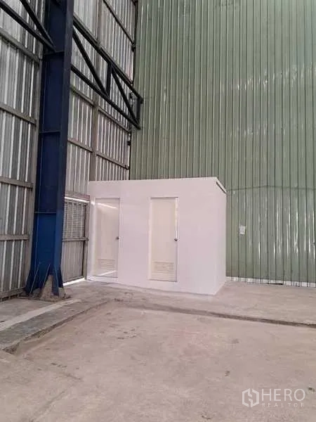 Warehouse for rent in Pak Kret, Nonthaburi - White restroom block built inside the warehouse beside the metal wall.