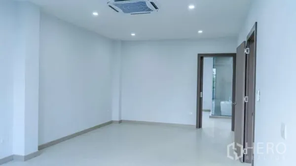 Detached House for rent or sale in Suan Luang, Bangkok - Bright empty living space with recessed lighting, built-in air conditioning and doors to adjoining rooms