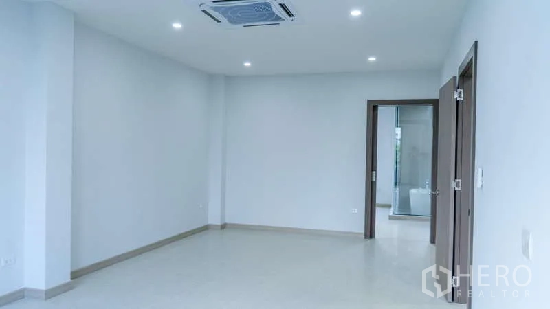 Detached House for rent or sale in Suan Luang, Bangkok - Bright empty living space with recessed lighting, built-in air conditioning and doors to adjoining rooms