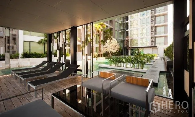 คอนโด ให้เช่าในWatthana, Bangkok - สระว่ายน้ำสไตล์รีสอร์ตของคอนโด มีเตียงอาบแดด มุมนั่งพักร่ม และสวนจัดแต่ง