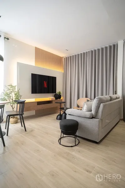 独立式住宅 出租在Huai Khwang, Bangkok - 全高窗帘、悬浮电视柜与氛围灯的客厅。