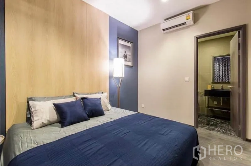 คอนโด ให้เช่าหรือขายในWatthana, Bangkok - ห้องนอนหลักผนังโทนฟ้าและลายไม้ พร้อมประตูเข้าสู่ห้องน้ำในตัว