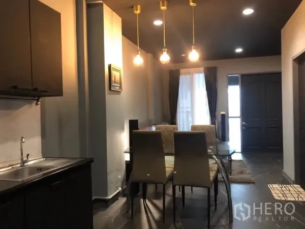 ทาวน์เฮาส์ ให้เช่าในBang Kapi, Bangkok - โต๊ะทานอาหารกระจก 6 ที่นั่ง ใต้โคมไฟสีทอง ใกล้ทางเข้า