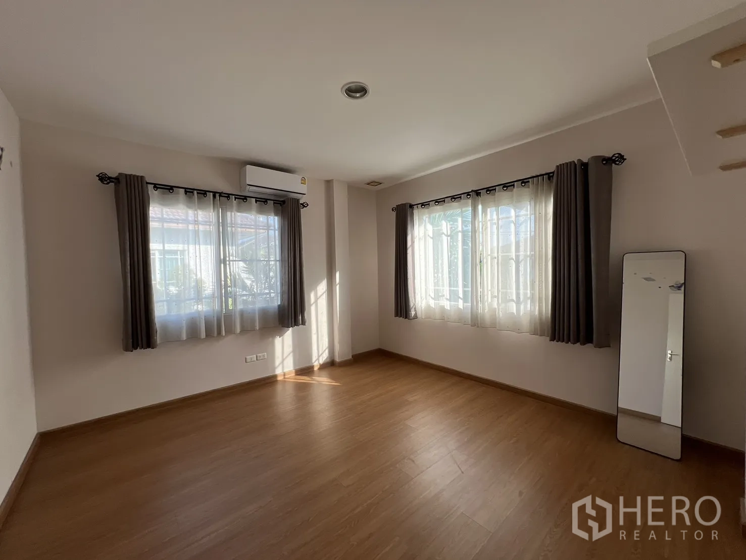 บ้านเดี่ยว for rent in Bang Kapi, Bangkok - ห้องมุมมีหน้าต่างสองด้านและพื้นไม้โทนอุ่น.