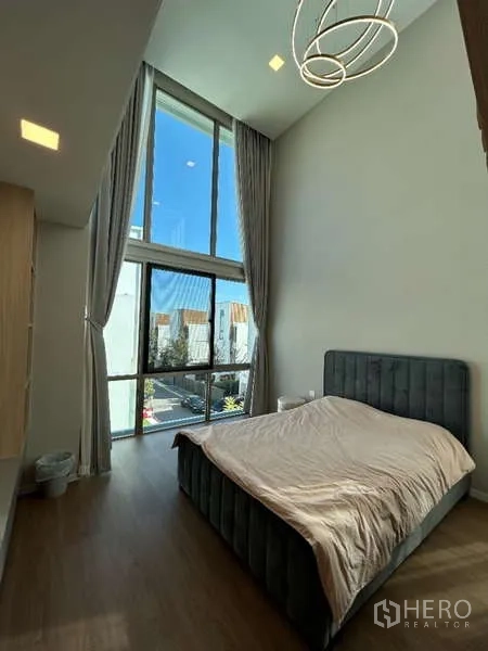 Detached House for rent in Saphan Sung, Bangkok - Bedroom with high ceiling and full-height windows bringing in ample daylight.