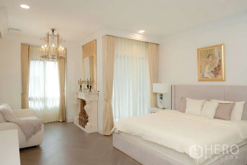 บ้าน ให้เช่าหรือขายในSaphan Sung, Bangkok - ห้องนอนมาสเตอร์สว่างไสว โคมไฟระย้า เตาผิงตกแต่ง หน้าต่างบานใหญ่ และเตียงบุผ้า