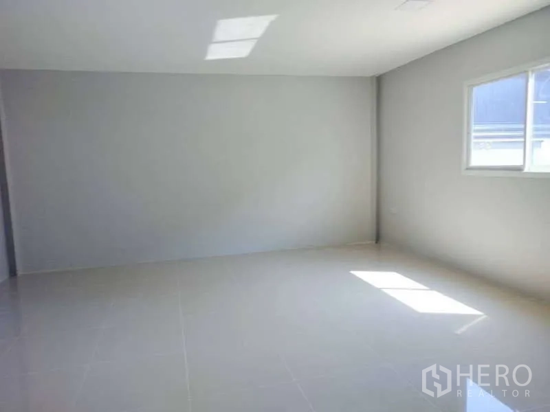 Warehouse for rent in Pathum Thani - Bright tiled office room with a window bringing in natural light.
