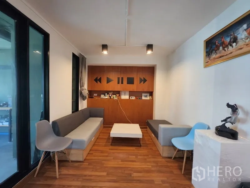 Home Office for sale - Cozy lounge with built-in cabinetry, wood flooring and modern ceiling lights.