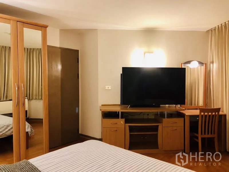 คอนโด ให้เช่าในPathum Wan, Bangkok - มุมห้องนอนมีชั้นวางทีวี โต๊ะทำงาน และผ้าม่านขนาดใหญ่