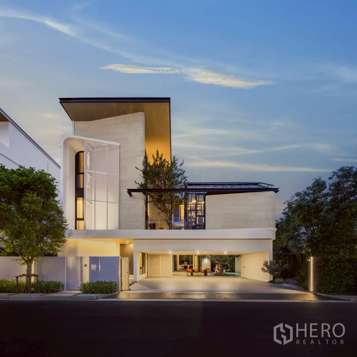 Detached House for rent in Saphan Sung, Bangkok - Twilight street view of a three-storey ultra‑modern detached house with covered parking and warm facade lighting.