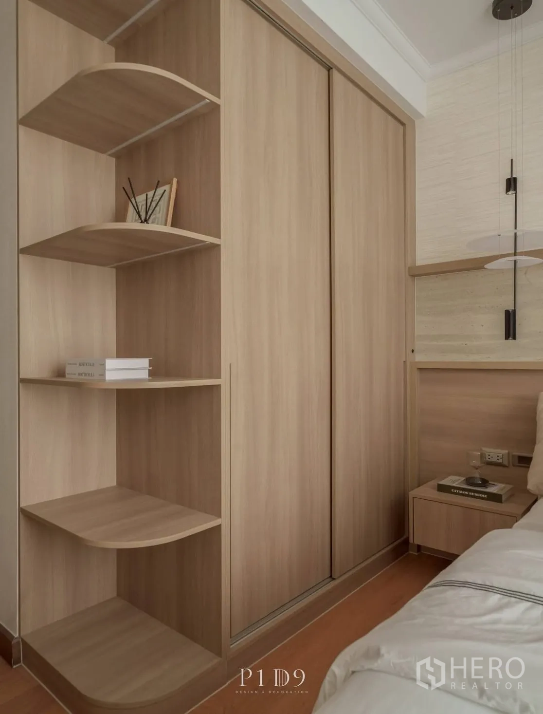 Condominium for rent in Watthana, Bangkok - Close-up of wood wardrobe with curved open shelving beside the bed.