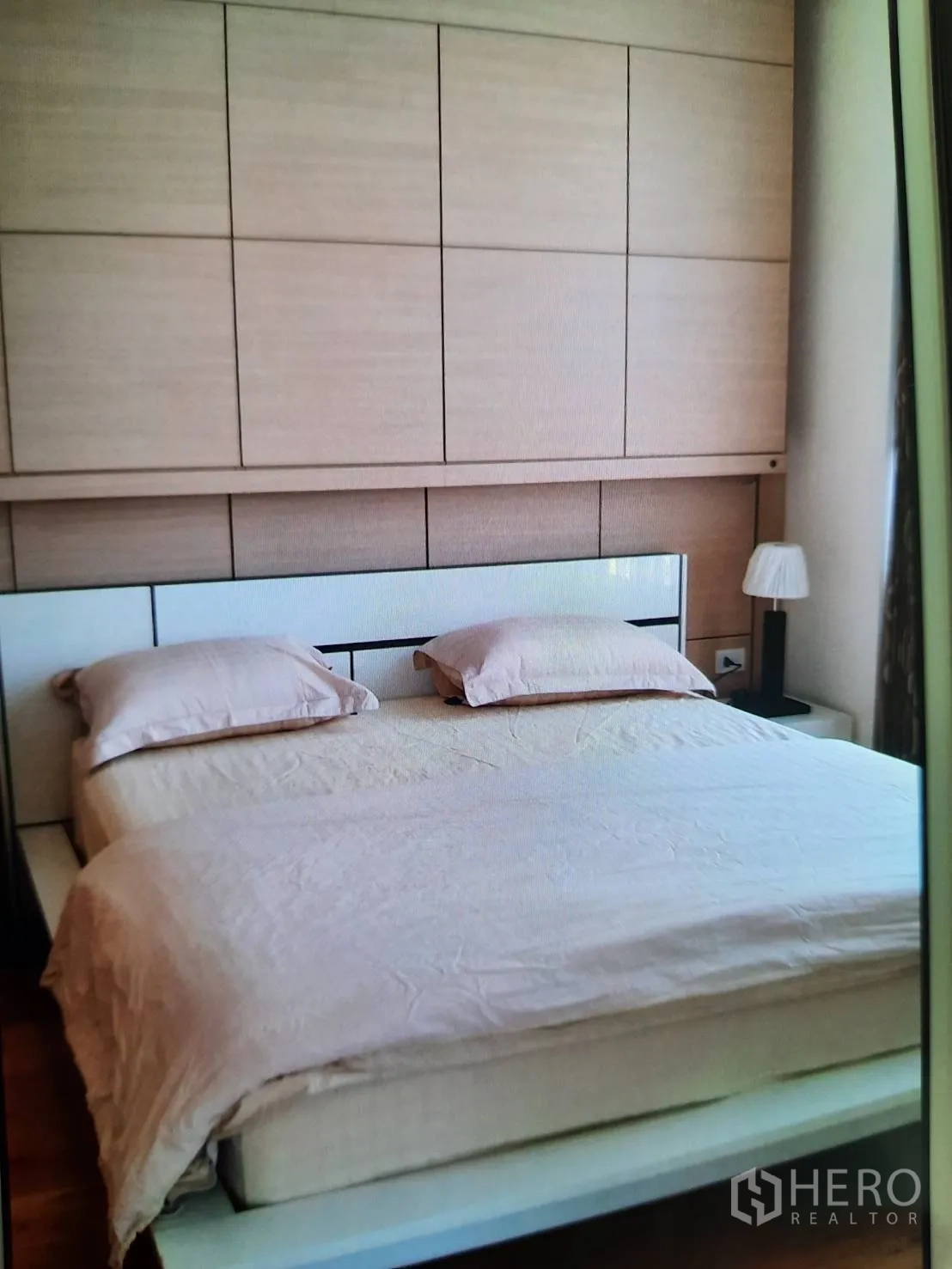 คอนโด ให้เช่าหรือขายในSathon, Bangkok - ห้องนอนใหญ่บรรยากาศอบอุ่น เตียงคิงไซส์ ผนังหัวเตียงไม้ และโคมไฟข้างเตียงรับแสงธรรมชาติ