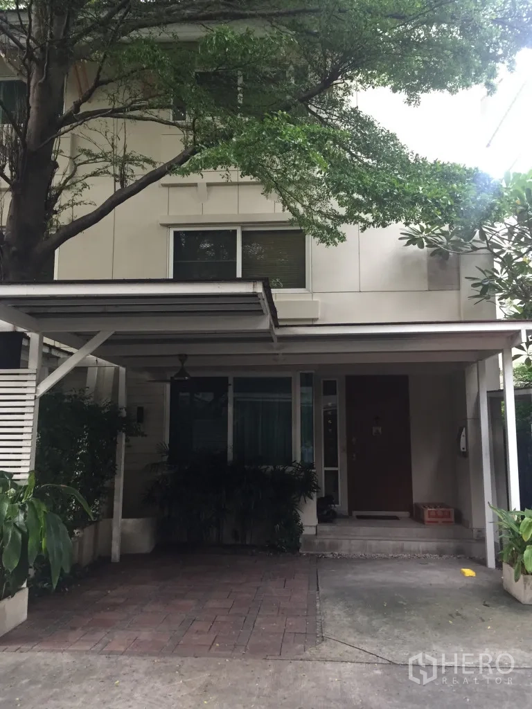 Detached House for rent in Watthana, Bangkok - Exterior facade of detached house with carport shaded by mature trees.