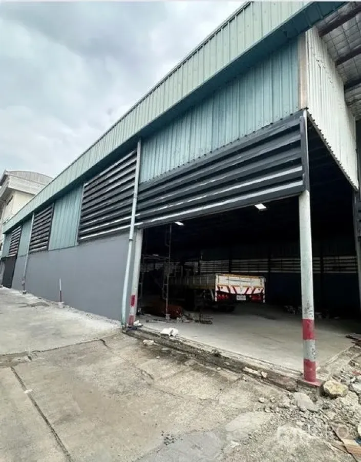 Warehouse for rent in Suan Luang, Bangkok - Side view of the warehouse facade with ventilation louvers and a wide loading bay in Bangkok.