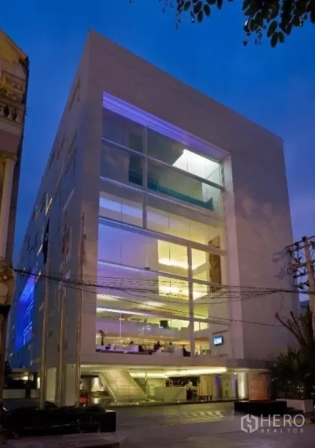 零售空间 出租在Watthana, Bangkok - 瓦他那曼谷现代多层商业建筑外观，黄昏时分带大面积玻璃立面。