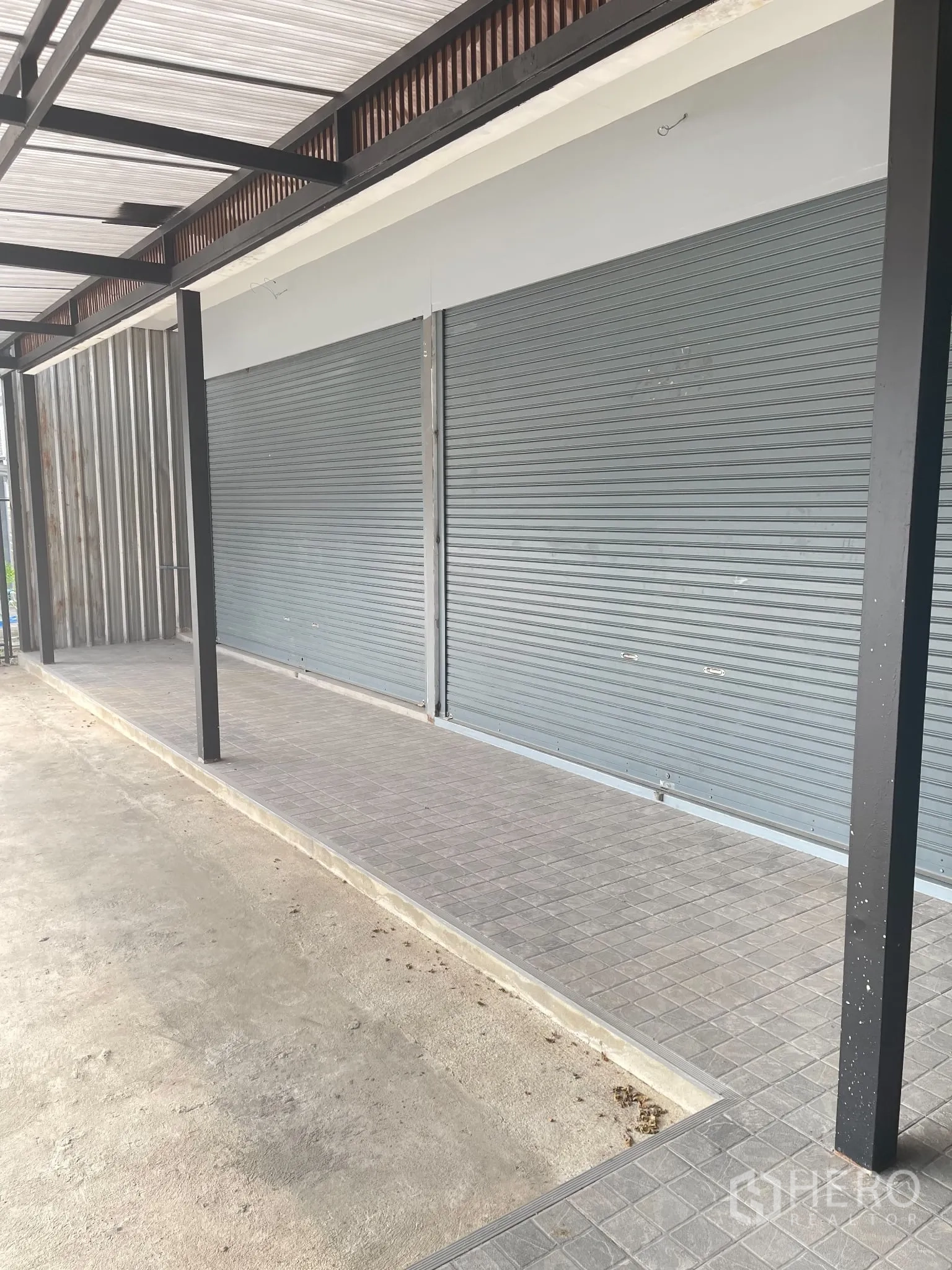 พื้นที่ขายของ for rent in Suan Luang, Bangkok - หน้าร้านประตูกลิ้งใต้กันสาด ทางเดินกระเบื้องและเสาเหล็ก