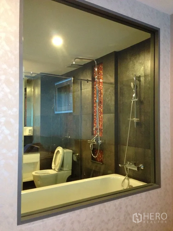 Condominium for rent or sale in Watthana, Bangkok - Glass‑walled bathroom featuring a soaking tub, rain shower, and mosaic accent in a modern condo.
