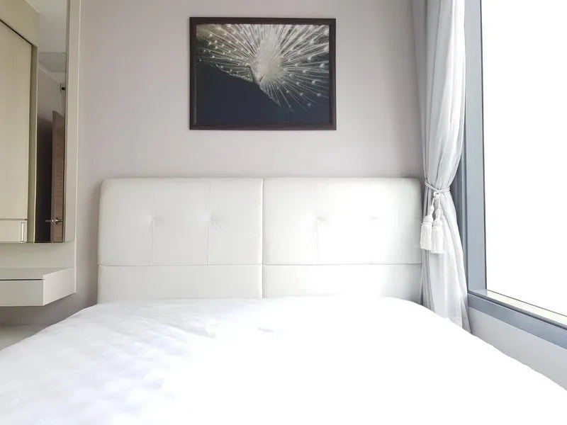 公寓 出租在Ratchathewi, Bangkok - 明亮卧室，白色软包床头板与大窗帘窗。