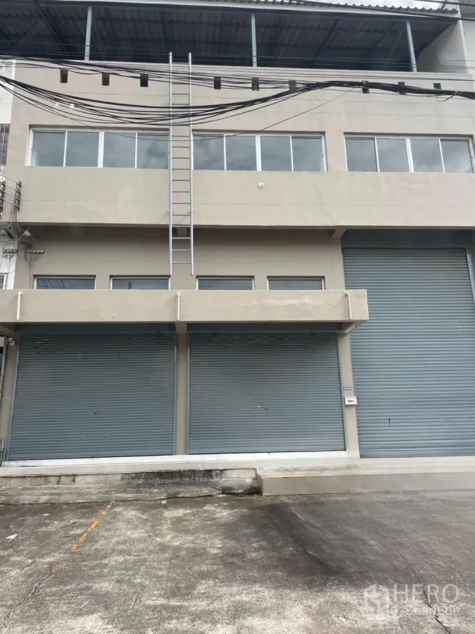 货栈 出租在Bang Phli, Samut Prakan - 北榄府邦普里仓库外立面，临街多卷闸门、装卸前场与顶部遮棚