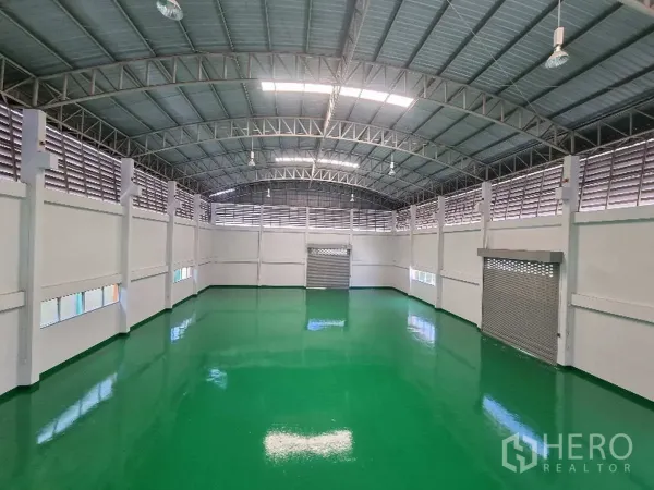 Factory for rent in Samut Prakan - Large production hall with high arched roof and polished green epoxy floor.