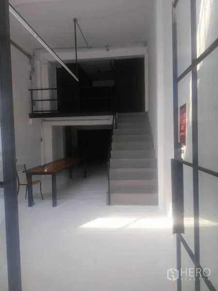 Shophouse for rent in Khlong Toei, Bangkok - Front retail space viewed from the entrance, showing staircase and mezzanine.
