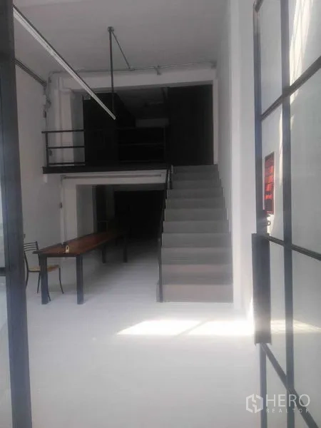 Shophouse for rent in Khlong Toei, Bangkok - Front retail space viewed from the entrance, showing staircase and mezzanine.
