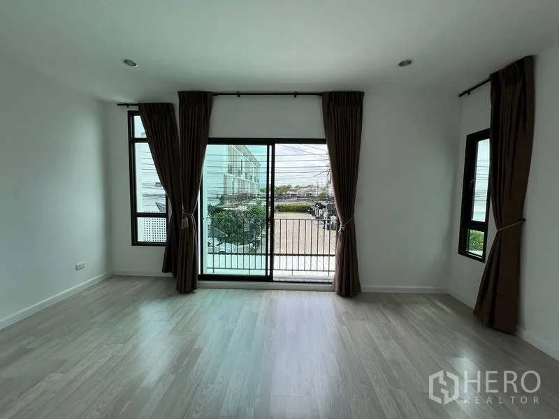 ทาวน์เฮาส์ ขายในBang Kapi, Bangkok - ห้องชั้นบนมีประตูกระจกสไลด์ออกสู่ระเบียง มองเห็นถนนโครงการ