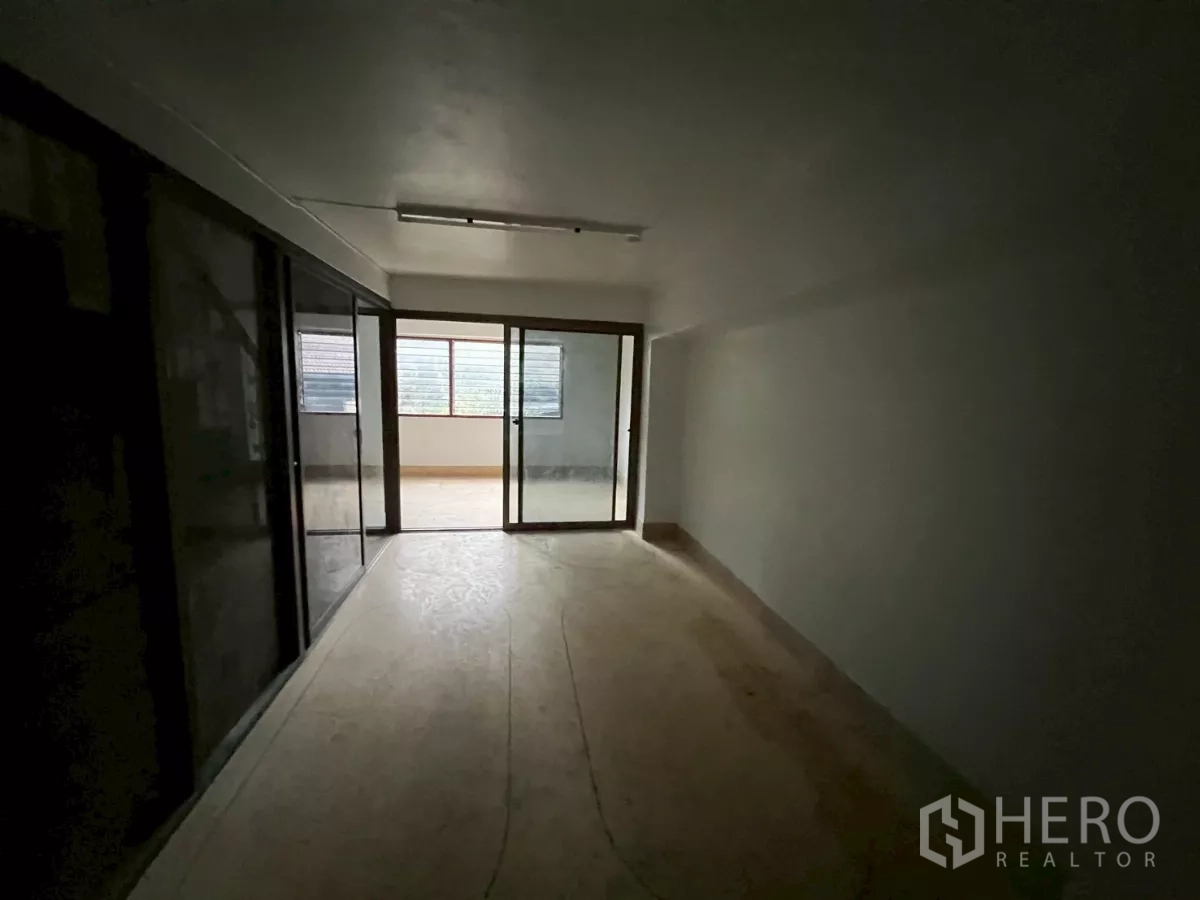 อาคารพาณิชย์ ให้เช่าในKhlong Toei, Bangkok - ห้องชั้นบนยาวต่อเนื่อง มีประตูกระจกบานเลื่อนออกสู่ระเบียงปิด.