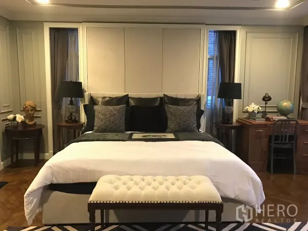 Townhouse for sale in Watthana, Bangkok - Spacious master bedroom with king bed, bench and side tables.