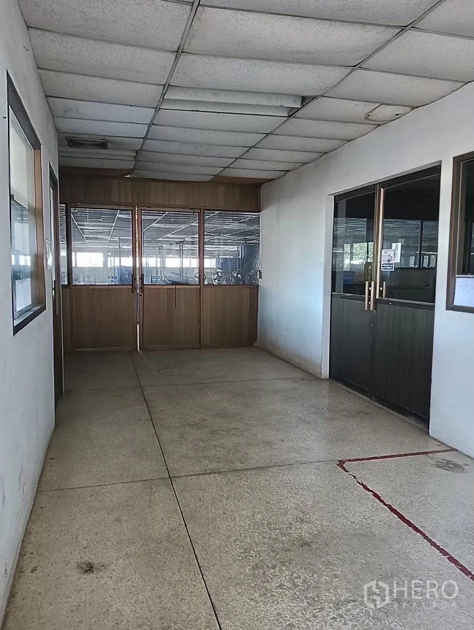 工厂 for sale in Lat Krabang, Bangkok - 走廊以玻璃与木质隔断分出通往生产区域的入口。