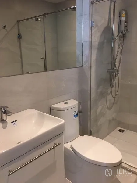 Condominium for rent in Watthana, Bangkok - Vanity, toilet and walk-in shower in a bright modern bathroom.