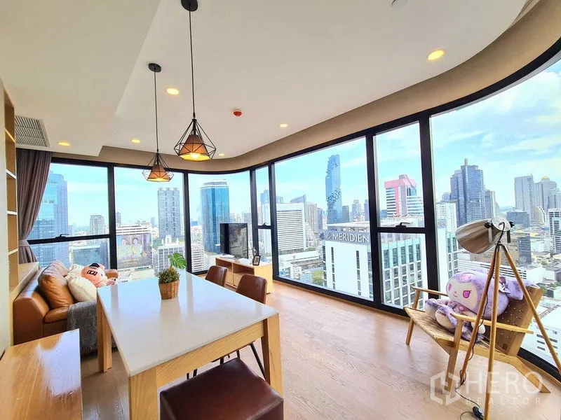 Condominium for rent in Bang Rak, Bangkok - Dining table with pendant lights set against full-height panoramic windows and skyline.