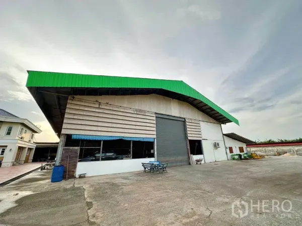 Warehouse for rent in Sai Noi, Nonthaburi - Front view of warehouse with high gable roof, big roller door and open parking apron.