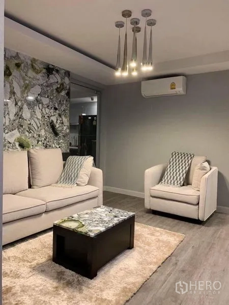 คอนโด ขายในKhlong Toei, Bangkok - ห้องนั่งเล่นอีกมุม มีโซฟา เก้าอี้เดี่ยว โต๊ะกลางหินอ่อน พรม และเครื่องปรับอากาศ