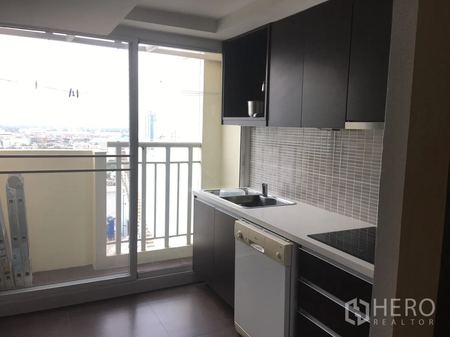 คอนโด ให้เช่าหรือขายในWatthana, Bangkok - ครัวแพนทรีติดระเบียง ตู้สีเข้ม เตาไฟฟ้า เครื่องล้างจาน มองเห็นวิวเมือง