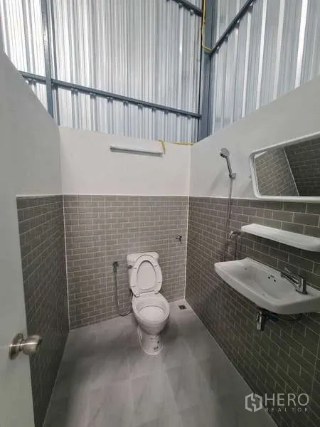 คลังสินค้า ให้เช่าในKhlong Toei, Bangkok - ห้องน้ำกระเบื้องสีเทาลายอิฐ มีโถสุขภัณฑ์ กระจก อ่างล้างหน้า และฝักบัว