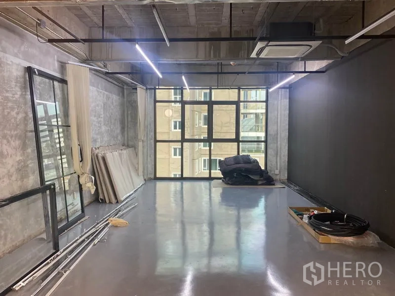 สำนักงาน ให้เช่าในKhlong Toei, Bangkok - ห้องทรงสตูดิโอ พื้นคอนกรีตขัดมัน ไฟแขวน และกระจกสูงจรดเพดาน.