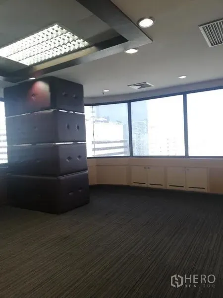 Office Space for rent in Watthana, Bangkok - Corner office with panoramic windows, city views, a dark feature column and built-in storage.