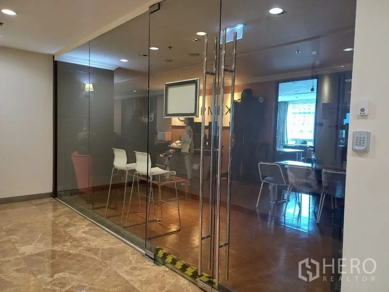 Office Space for rent - Glass-fronted office entrance with double doors, bar stools and a visible meeting area.