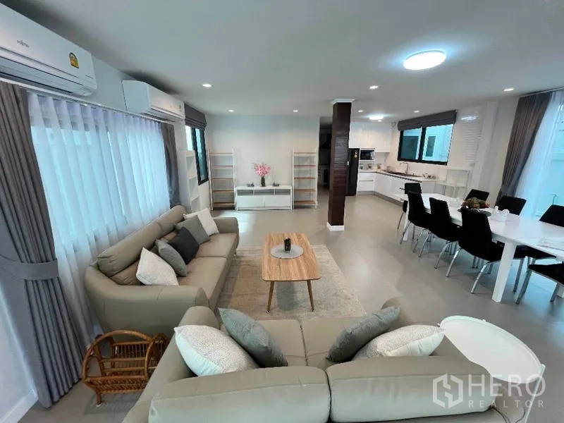 独立式住宅 出租在Phaya Thai, Bangkok - 开放式起居区，沙发组连通餐厅与厨房。