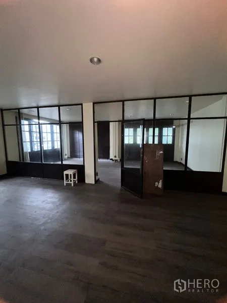 店屋 出租在Watthana, Bangkok - 楼上办公区，黑框玻璃隔断与深色木地板。