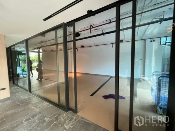 Office Space for rent in Watthana, Bangkok - Modern office corner with sliding glass partitions and industrial-style ceiling.