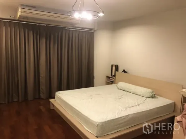 公寓 出租在Bang Rak, Bangkok - 宽敞卧室，双人床、吊灯、长窗帘与抛光木地板