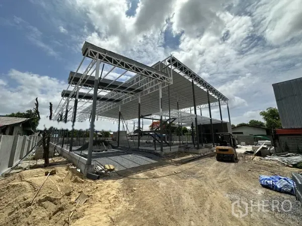 货栈 出租在Lat Krabang, Bangkok - 曼谷拉德克拉邦钢结构仓库建设中，高挑屋顶与开放跨距，前方为碎石场地。